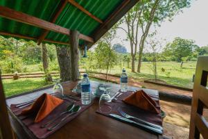 a table with silverware and bottles of water on it at Sigiri Close-up View Guest in Sigiriya