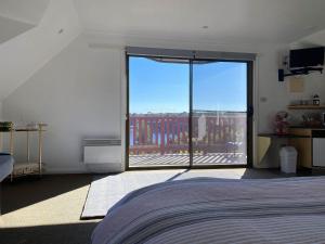 een slaapkamer met een bed en een groot glazen raam bij Gordon Gateway in Strahan