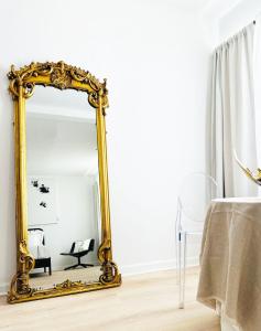 un miroir en or dans une pièce avec une table dans l'établissement Jazz Hotel Palm Springs, à Palm Springs