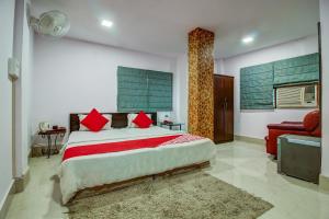 una camera con un grande letto e un divano rosso di OYO Flagship Spc & Span a Jamshedpur