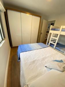 a bedroom with two beds and a bunk bed at Canto do Forte experience in Praia Grande