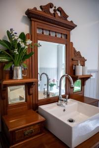 y baño con lavabo y espejo. en Ard Choille Cottages, en Mount Macedon