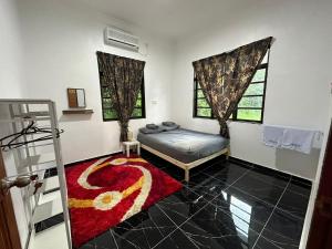 a bedroom with a bed and a red rug at Rania Riverview Guesthouse in Kuala Berang