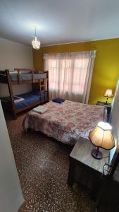 1 dormitorio con 1 cama, literas y mesa en La Cúpula Hostel & Camping, en Tarija