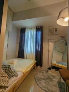 um pequeno quarto com uma cama e um espelho em Staycation in Manila em Manila