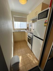 a kitchen with white appliances and a tile floor at George Bass Motor Inn in Nowra