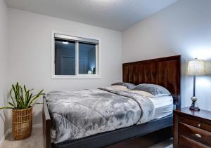 a bedroom with a bed and a window at Stylish/4Bedroom/FreeParking/IndoorFirePlace in Calgary