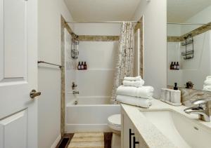 a bathroom with a tub and a toilet and a sink at Stylish/4Bedroom/FreeParking/IndoorFirePlace in Calgary