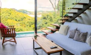 un soggiorno con divano e tavolo di Tropical Loft Home - Ocean View a San Juan del Sur