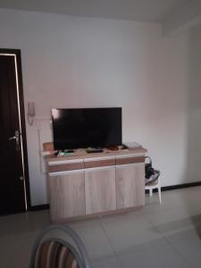 a flat screen tv on a wooden cabinet in a room at Apartamento ótima localização in Torres