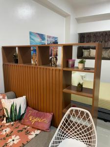 a room with a wooden wall with a shelf and a chair at WV Tower 1 Studio in Iloilo City