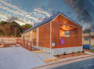 a small building with a staircase next to a street at Reflections Bermagui - Holiday Park in Bermagui