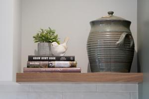 a stack of books and a vase on a shelf at Dunkeld House - Beautiful country accomodation in Dunkeld