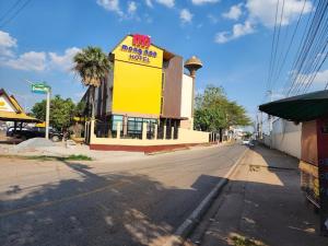 un edificio amarillo al lado de una calle en Mongnon Hotel โรงแรมมองนอน อุดรธานี, en Udon Thani