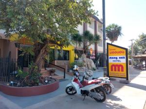 una motocicleta estacionada en una acera al lado de un edificio en Mongnon Hotel โรงแรมมองนอน อุดรธานี en Udon Thani