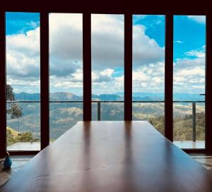 a large wooden table in front of a large window at Hunnasgiriya Oncloud 9 in Hunnasgiriya