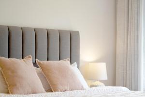 a bedroom with a large bed with white sheets and pillows at Dunkeld House - Beautiful country accomodation in Dunkeld