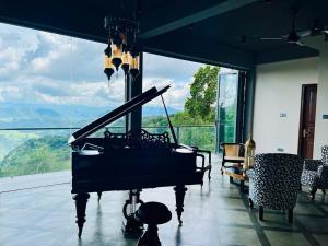 a piano in a room with a large window at Hunnasgiriya Oncloud 9 in Hunnasgiriya