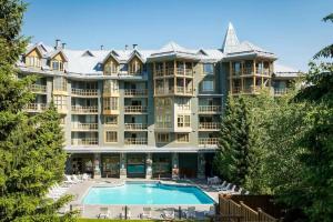 a large apartment building with a large swimming pool at 900 SQFT 2 Bed 2 Bath Renovated Suite at Cascade Lodge in Whistler Village Sleeps 6 in Whistler