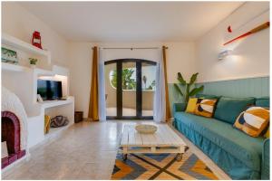 ein Wohnzimmer mit einem grünen Sofa und einem Couchtisch in der Unterkunft Casa Flor de Sal Apartment in Carvoeiro