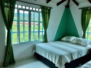 a bedroom with a bed and a large window at Villa Lela, best way to chill & relax ! in Lemos