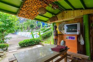 a patio with a wooden table and a tv on it at Sun Lu Holiday Homestay in Jiamin