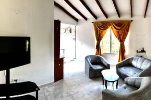 a living room with two couches and a tv at Villa Lela, best way to chill & relax ! in Lemos