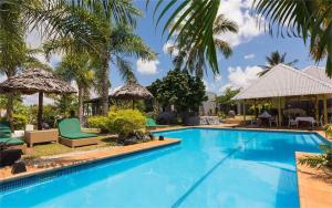 einen Pool mit Stühlen und Sonnenschirmen neben einem Haus in der Unterkunft Coconut Palms Resort & Diamond Casino in Port Vila