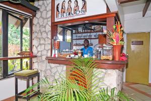 un hombre sentado en un bar en un restaurante en Coconut Palms Resort & Diamond Casino, en Port Vila
