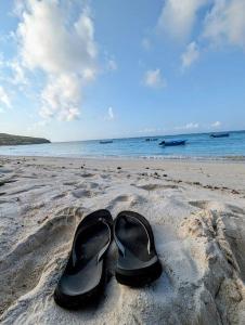 Rodrigues Island的住宿－Résidence Véronia，坐在沙滩上的一双黑鞋