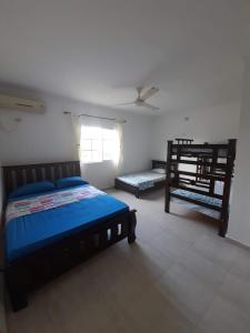 a bedroom with two beds and a ceiling fan at Ukiyo Cabin in Santa Marta