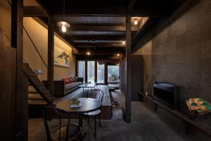 a living room with a couch and a table and a tv at Rinn Premium Nijo Castle North in Kyoto