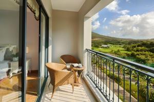 芽莊的住宿－Nha Trang Marriott Resort & Spa, Hon Tre Island，设有一个配有桌椅并享有美景的阳台。
