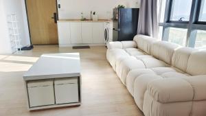 a living room with a white couch and a table at A1. The Ins @ Aurpra Place beside Pavillion Bukit Jalil in Kuala Lumpur