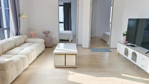 a living room with a white couch and a tv at A1. The Ins @ Aurpra Place beside Pavillion Bukit Jalil in Kuala Lumpur