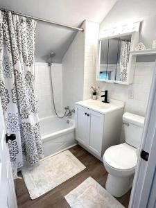 a white bathroom with a toilet and a sink at A Lovely Retreat in St Paul in Saint Paul