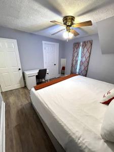 a bedroom with a large bed and a ceiling fan at A Lovely Retreat in St Paul in Saint Paul