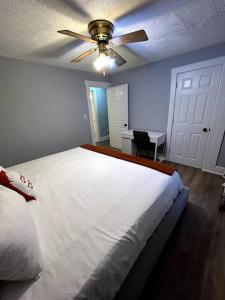 a bedroom with a white bed and a ceiling fan at A Lovely Retreat in St Paul in Saint Paul