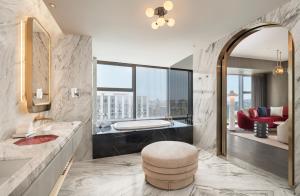 a bathroom with a tub and a large mirror at W Xiamen-Next to shopping center&Exhibition Center in Xiamen