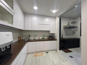 a kitchen with white cabinets and a sink at Spacious Home @ Kuching City Ctr in Kuching
