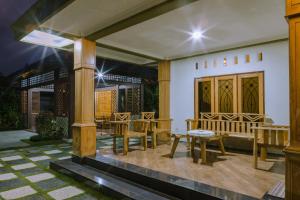 a patio with wooden furniture and a table and benches at Bait Nahwa in Mataram