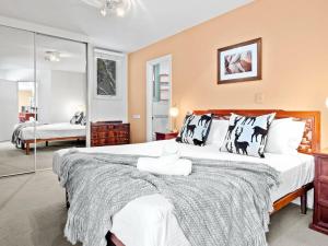 a large bedroom with two beds and a mirror at Aspect 2 in Thredbo