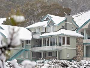 a large house with snow on top of it at Aspect 2 in Thredbo