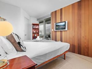 um quarto com uma cama e uma televisão na parede em Aspect 2 em Thredbo