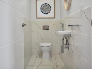 a white bathroom with a toilet and a sink at Alloura 2 in Jindabyne