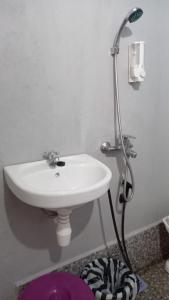 a bathroom with a white sink and a shower at Tange Guest House in Ruteng +35 photos