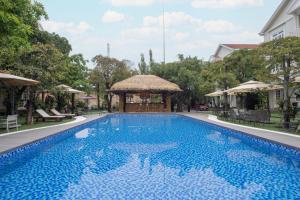 a large blue swimming pool with a gazebo at Hidden Mansions Saigon Resort in Ho Chi Minh City