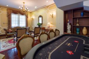 a living room with a pool table and chairs at Hidden Mansions Saigon Resort in Ho Chi Minh City