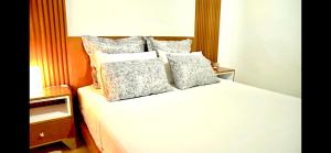 ein Bett mit vielen Kissen darüber in der Unterkunft Chez Charifa in Asilah