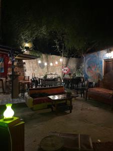 a patio with couches and tables and a table with a lamp at Casamolle Hostel in Tilcara